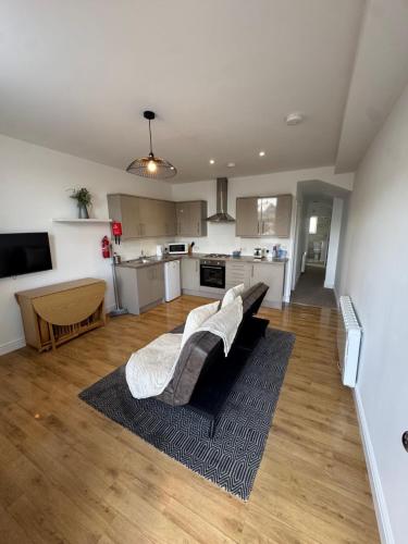 a living room with a couch and a kitchen at Valletta House Holiday Apartments in Skegness