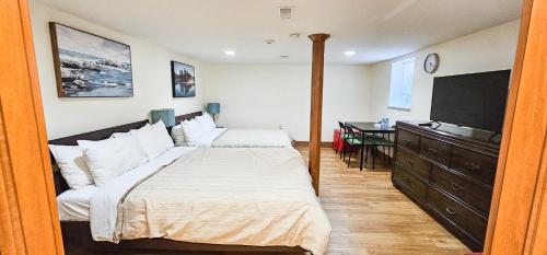 a bedroom with a bed and a dresser with a television at Anna's Bed & Breakfast in Niagara Falls