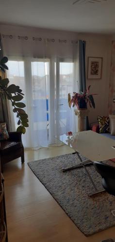 - un salon avec une table en verre et un tapis dans l'établissement Le lutetia 06, à Cannes