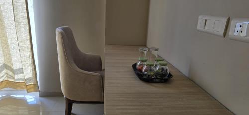Una mesa con una silla y dos botellas encima. en Madhuban Stays, en Mathura