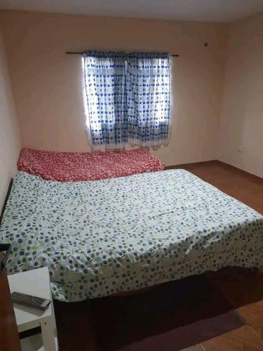 グアイマレンにあるResidencia Lescanoのベッドルーム1室(花の散布のあるベッド1台、窓付)