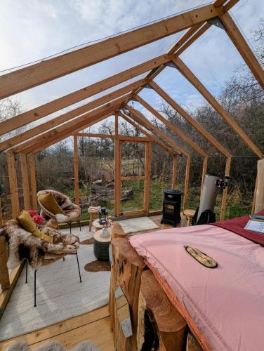 une chambre avec un lit et des chaises dans une serre dans l'établissement Insolite Cabane du Rêveur, à Pagny-sur-Moselle