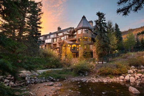 a large house with a river in front of it at Gravity Haus Vail in Vail