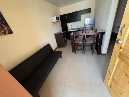 a living room with a black couch and a table at Bandera Beach Cabins in Parrita