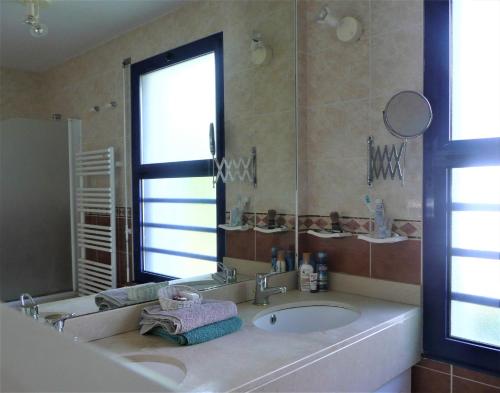 une salle de bain avec une baignoire, un lavabo et une fenêtre dans l'établissement Villa Destordeur, à Moliets-et-Maa