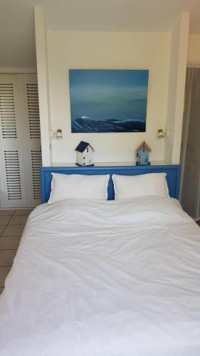 un grand lit blanc avec deux maisons sur le mur dans l'établissement Villa Destordeur, à Moliets-et-Maa