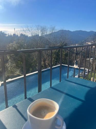 a cup of coffee sitting on a table on a balcony at Maison Gabrielle in Vals-les-Bains