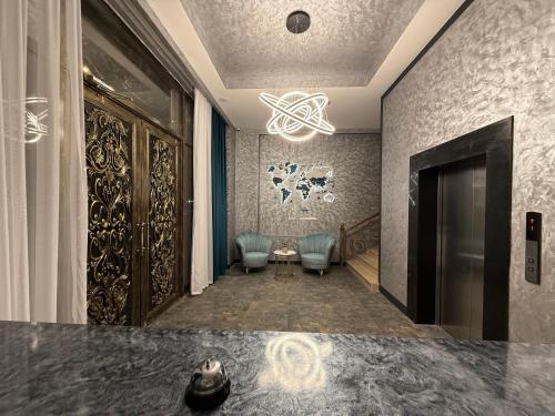 a lobby with two chairs and a table and a chandelier at Black Mont İnn Hotel in Baku