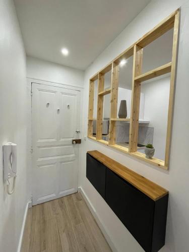 un couloir avec une porte blanche et une fenêtre dans l'établissement Charmant T2 avec cour extérieure, à Cholet