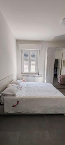 a white bedroom with a large bed in it at Lauretana Dreams in Loreto Aprutino