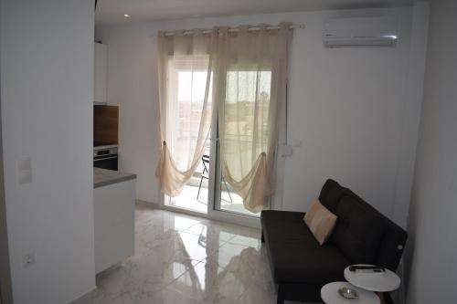 ネア・カリクラティアにあるBella Mare luxury Livingのソファと大きな窓のあるリビングルーム