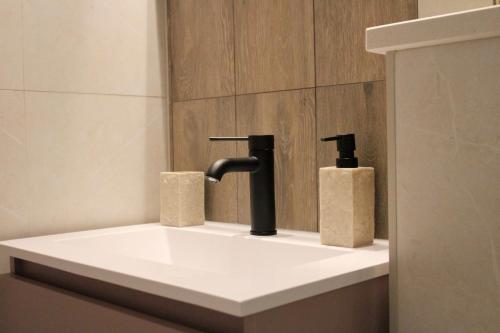 a bathroom with a sink with two soap dispensers at Studio apartment Laura-spacious studio on the main beach in Makarska