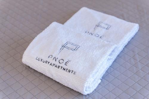 a white napkin with three manufacturers on it at PNOẼ Luxury Apartments in Lourdhata