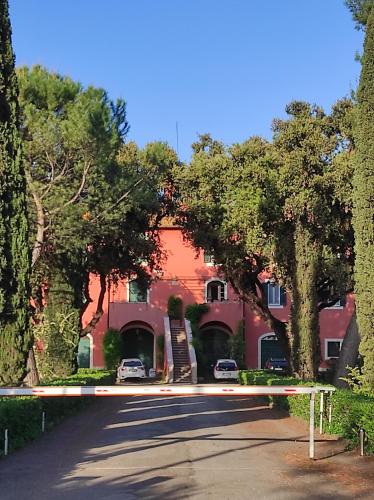 un edificio rojo con árboles frente a una calle en The Farm House - Fast WiFi - Free Parking, en Ponte Lucano