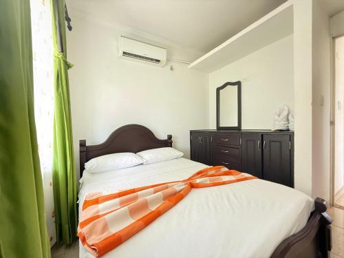 a bedroom with a bed with a dresser and a mirror at Cabaña Yopal - Yopo Resort in Yopal