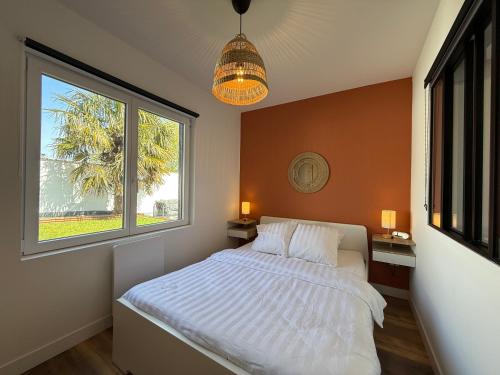 une chambre avec un lit blanc et une fenêtre dans l'établissement Maison avec jardin à 50m du Lac, à Ardres