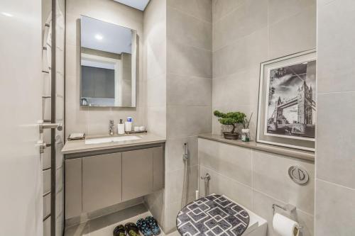 a bathroom with a toilet and a sink and a mirror at Silhouette Suite Studio by JK in Sharjah