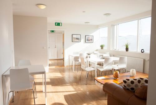 sala de estar con sofá, mesa y sillas en Lyngás Guesthouse, en Egilsstadir