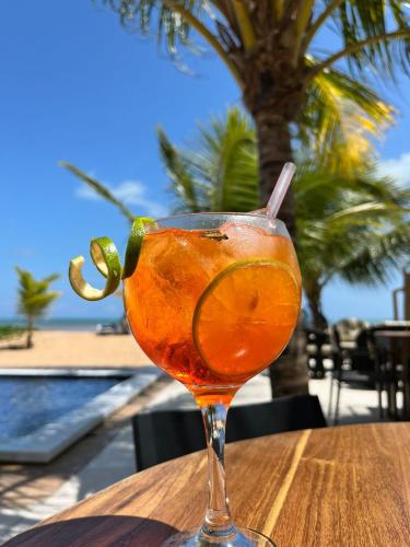 a drink sitting on top of a wooden table at Pousada D'Azul in Japaratinga