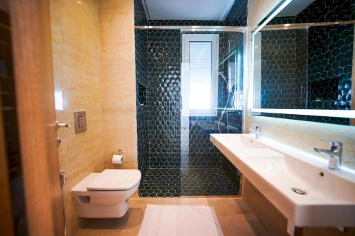 a bathroom with a shower and a toilet and a sink at Villa Hermes: Seaside and luxurious in El Haouach