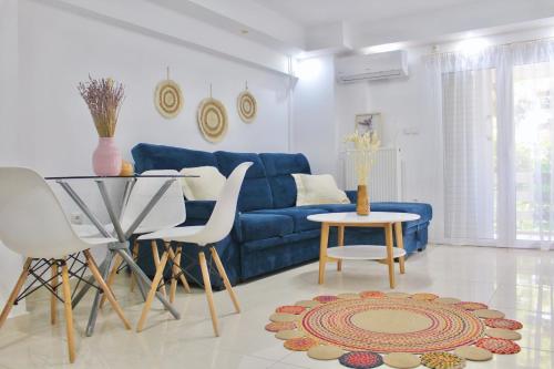 a living room with a blue couch and a table at Bright and Peaceful Apartment near Varkiza beach in Varkiza