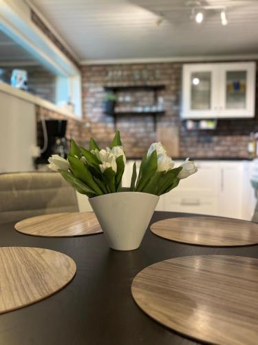 a table with a vase with white flowers on it at Hagavägen 1 Lägenhet in Grebbestad
