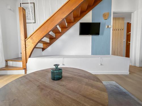 un vase assis sur une table dans une pièce avec escalier dans l'établissement Duplex cosy idéal pour familles à 200m de la plage, à Blonville-sur-Mer