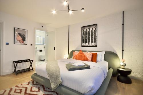 a bedroom with a large bed with orange pillows at Newly Refurbished w/ River Views in London