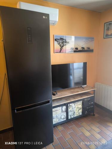 Cette chambre comprend un réfrigérateur noir et une télévision. dans l'établissement Studio, aux Lecques