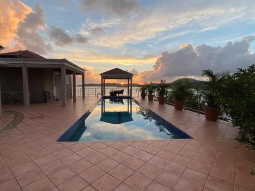a swimming pool with a gazebo on a patio at Oceanfront Cottage with Pool in East End