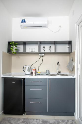 a kitchen with a sink and a black refrigerator at Lihnid Apartments in Ohrid
