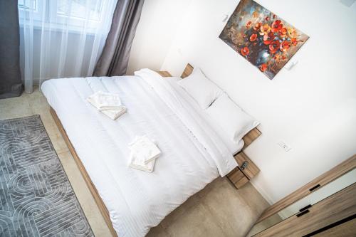 a bedroom with a bed with white sheets and pillows at Lihnid Apartments in Ohrid