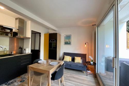 une cuisine et un salon avec une table et un canapé dans l'établissement Cosy and refined 1-bedroom apartment with garden, à La Rochelle
