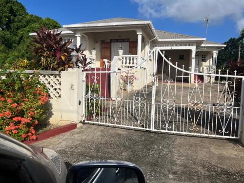 a white gate in front of a house at GNC Guesthouse in Saint Peter