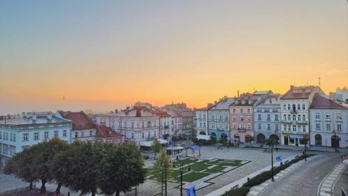 a group of buildings in a city at sunset at APARTAMENT GRODZKA1, 100 m2 przy przemyskim rynku z widokiem na rynek i panoramę miasta in Przemyśl