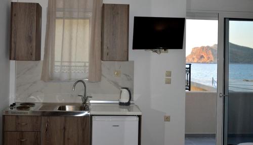 a kitchen with a sink and a tv on the wall at Tile Apartments #5 in Agia Marina Nea Kydonias