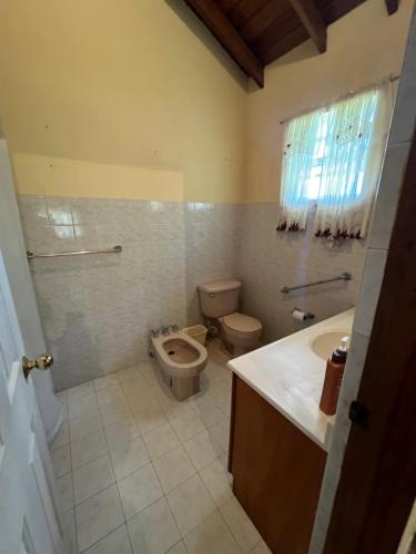 a bathroom with a toilet and a sink at GNC Guesthouse in Saint Peter