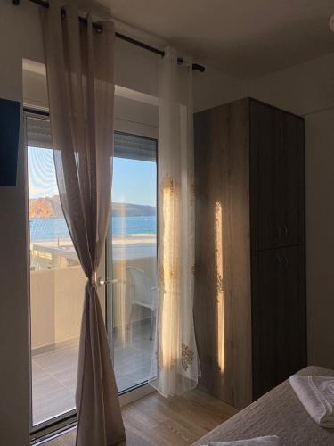 a bedroom with a large window with a view of the ocean at Tile Apartments #5 in Agia Marina Nea Kydonias