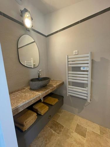 une salle de bain avec un lavabo et un miroir dans l'établissement La maison du soleil, à Mazan