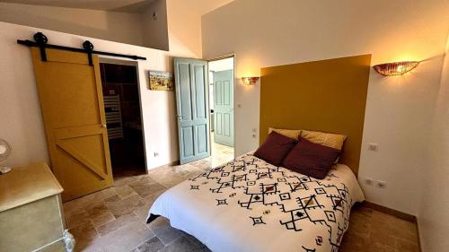 une chambre avec un lit avec des lettres noires dessus dans l'établissement La maison du soleil, à Mazan