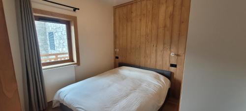 une petite chambre avec un lit et une fenêtre dans l'établissement Vanoise Luxe Escape - Champagny La Plagne, à Champagny-en-Vanoise