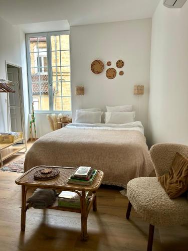 une chambre avec un lit, une table et une chaise dans l'établissement Le Brou, appartement de caractère du centre historique de Sarlat, à Sarlat-la-Canéda