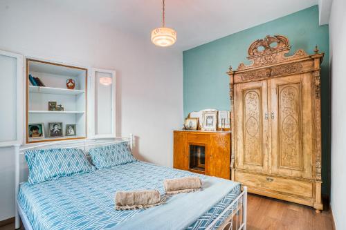 a bedroom with a bed and a large wooden cabinet at Masticha's Antistress House in Armólia