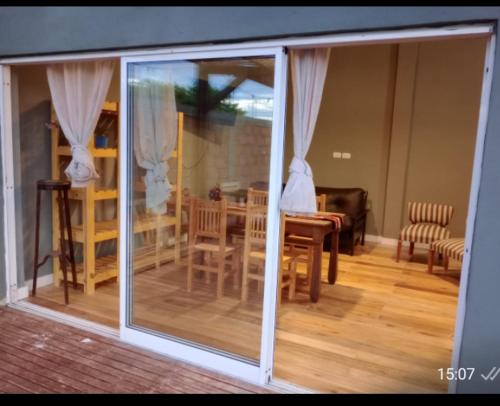 Una puerta corrediza de vidrio de una habitación con una mesa y sillas. en Lamora, en La Criolla