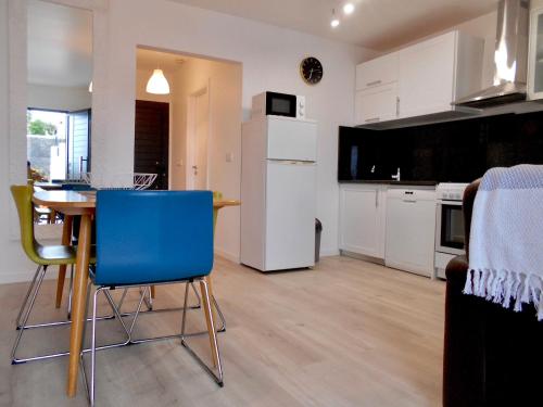 a kitchen and dining room with a table and blue chairs at Casa Bamboo central Funchal Villa in Funchal