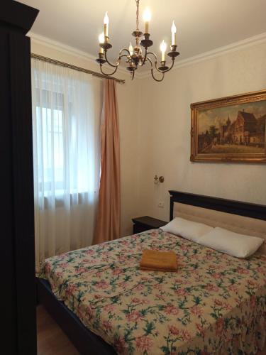 a bedroom with a bed and a chandelier at Toni s Luxury Central Place in Braşov