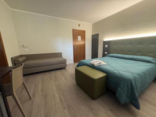 a bedroom with a bed and a couch at Da Noi Trattoria Hotel in Vergato