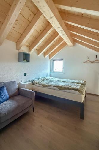 a bedroom with a bed and a couch at La Clef des Franches in Saignelégier