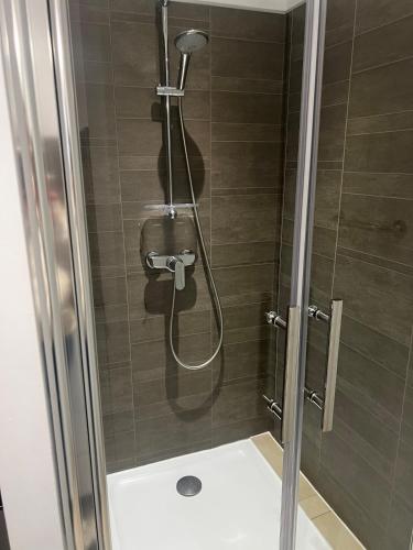 une douche avec une porte vitrée dans une salle de bain dans l'établissement T2 le Côte d'Azur, au Lavandou