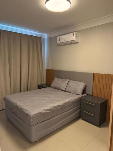 a bedroom with a bed and a air conditioner at Apartamento 207 varias piscinas in Bombinhas